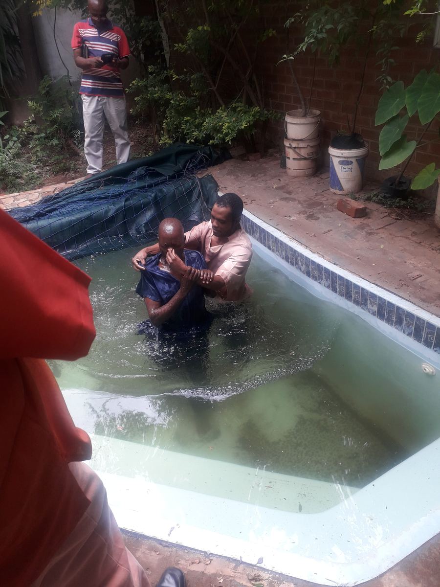 A brother lifts a believer out of the water after a baptism, a joy of our church of Christ in Laudium